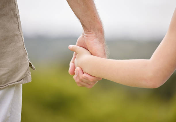 Baby daughter hand holding mother finger with love