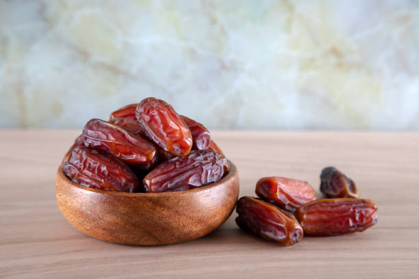 istock Bowl of dates fruit on colorful wooden background 1388450344