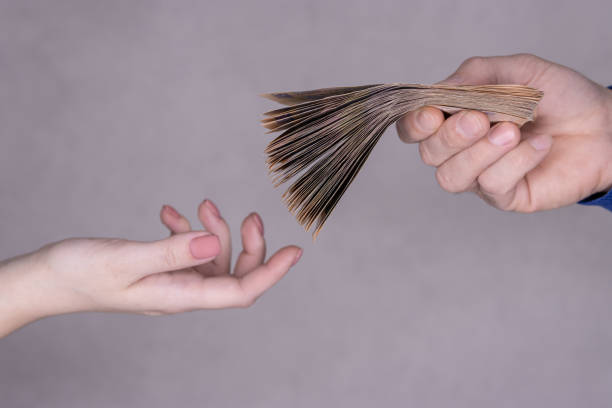 manos dando dinero aislado sobre fondo gris. concepto financiero - human hand beak currency stack fotografías e imágenes de stock