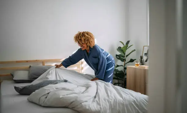 Photo of Beautiful Woman Making her Bed in the Morning