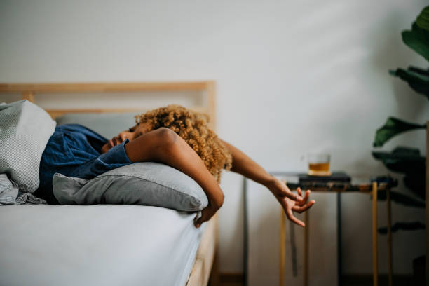 an anonymous woman sleeping in her bedroom in the morning - wake up stretching women black imagens e fotografias de stock