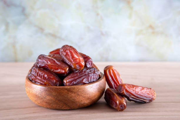 istock Bowl of dates fruit on colorful wooden background 1388451702