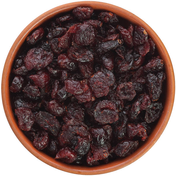istock Dried cranberries in a brown ceramic bowl isolated on white background. 1388454505