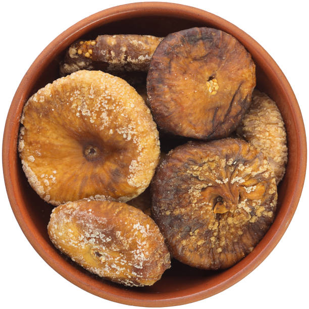 istock Dried figs in a brown ceramic bowl isolated on white background. 1388454511