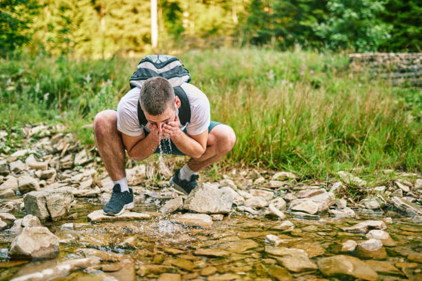 istock Man drinking fresh spring water while trekking. Selevtice focus 1388463639
