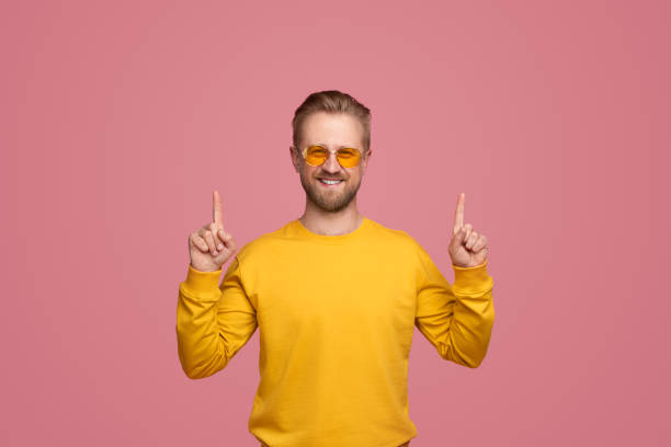 istock Stylish hipster pointing up in studio 1388469229