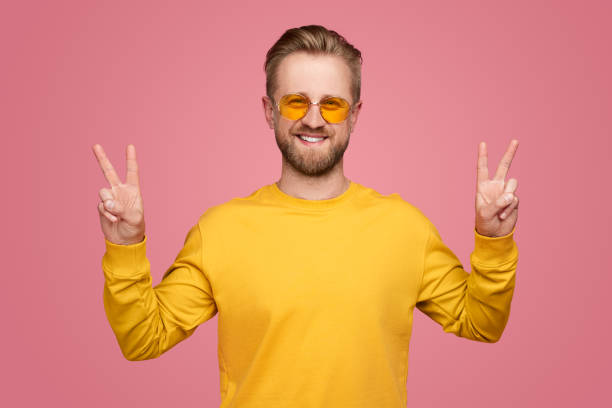 istock Cheerful man showing V sign in studio 1388469235