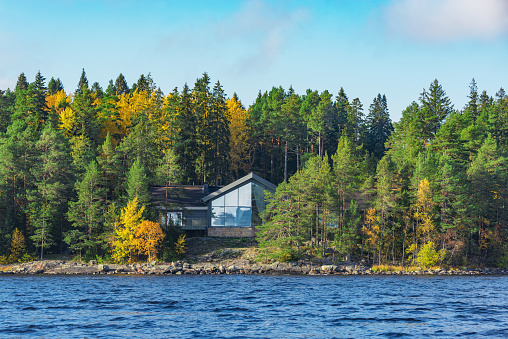 Luxury house in the autumn forest by the lake shore.