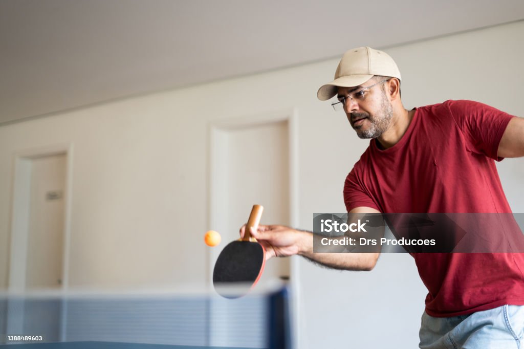 playing ping pong Friends playing ping pong at home Table Tennis Stock Photo