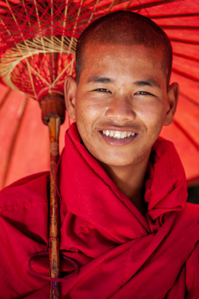 Young Buddhist monk posing next to one of ancient temples in Bagan, Myanmar (Burma)