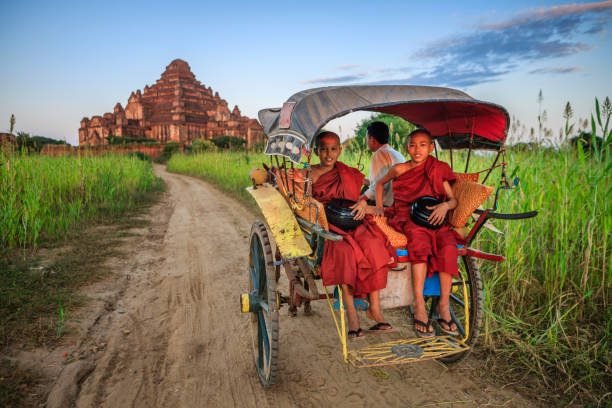 Young Buddhist monks on the horse cart Novice Buddhist Monks sitting in horse pulled cart,  ancient temples of Bagan on the background, Myanmar (Burma) bagan archaeological zone stock pictures, royalty-free photos & images
