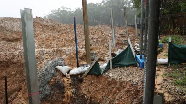 Steel posts used for retaining wall on development site 4K shot during pouring rain
