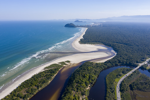 Aerial view of the coast of São Paulo including an environmental reserve of the Atlantic forest and the anointed itaguaré River with the beach and the Sea. Tourist site.