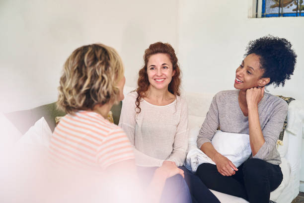 istock Female friends having a good conversation while sitting on couch 1388493047