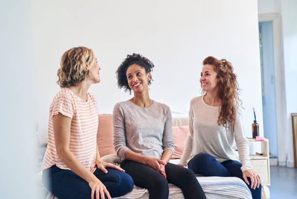 istock Cheerful adult women talking while sitting on bed 1388493068