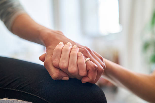 istock Woman supporting female friend while holding hands 1388493082