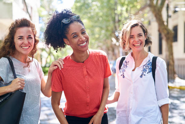 istock Female friends standing on street while looking at the camera 1388493126
