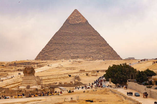 туристы и коренные жители вышли с плато гиза перед закрытием - giza pyramids sphinx pyramid shape pyramid стоковые фото и изображения