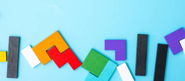 istock colorful wood puzzle pieces on blue background, geometric shape block with copy space. Concepts of logical thinking, Conundrum, solutions, rational, strategy, world logic day and Education 1388497694
