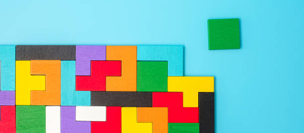 istock colorful wood puzzle pieces on blue background, geometric shape block. Concepts of logical thinking, Conundrum, solutions, rational, strategy, world logic day and Education 1388497708