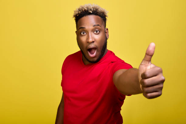 istock Winner's gesture of a dark-skinned surprised guy close-up in the frame 1388497918