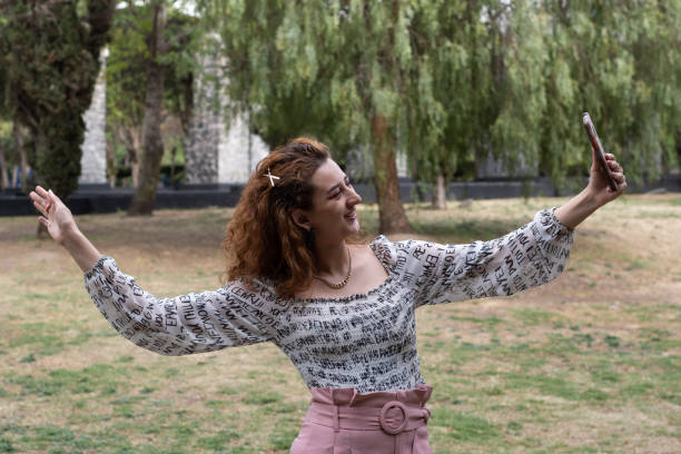 istock Woman using her cellphone in a park 1388504293