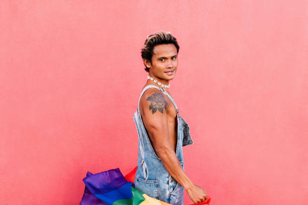 istock Handsome guy posing outdoors with LGBT flag and looking at camera 1388504875
