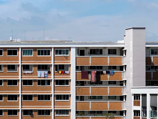 Laundry hanging on bamboo poles, out to dry in the sun, in a quiet residential neighbourhood in Singapore.