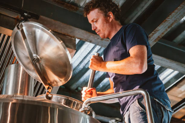istock Male worker operating machinery in brewery 1388510824