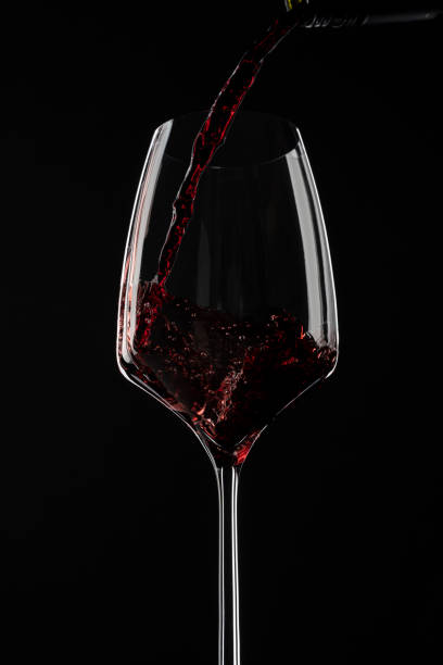 istock Red wine pouring in a glass from a bottle 1388512133
