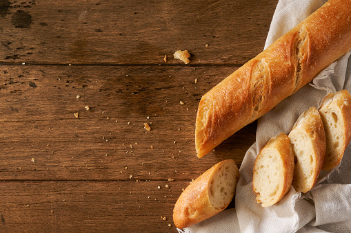 fresh homemade baguette on a wooden background.