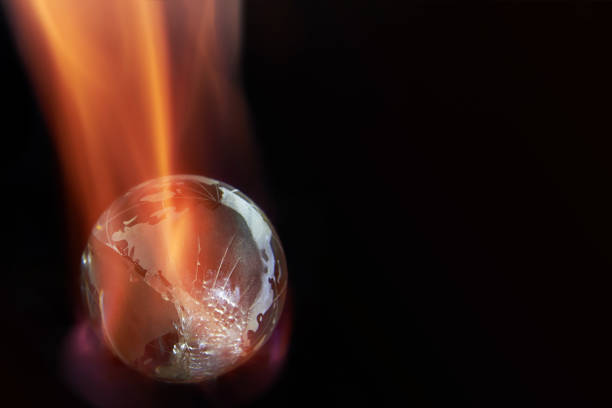 istock Glass planet earth on fire on black background, copy space. 1388513935