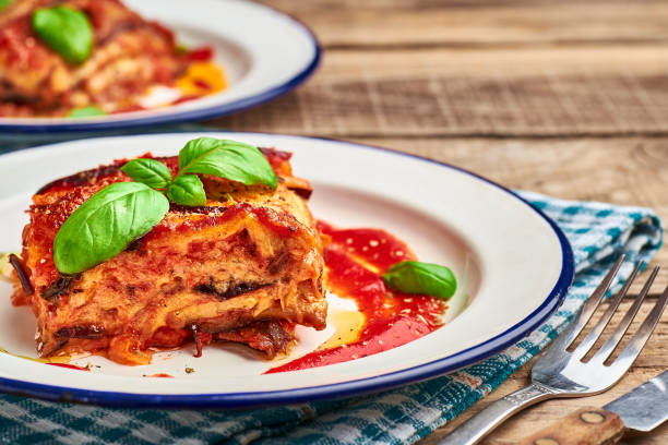 berenjena parmigiana sobre mesa rústica de madera. - aubergines parmesan fotografías e imágenes de stock