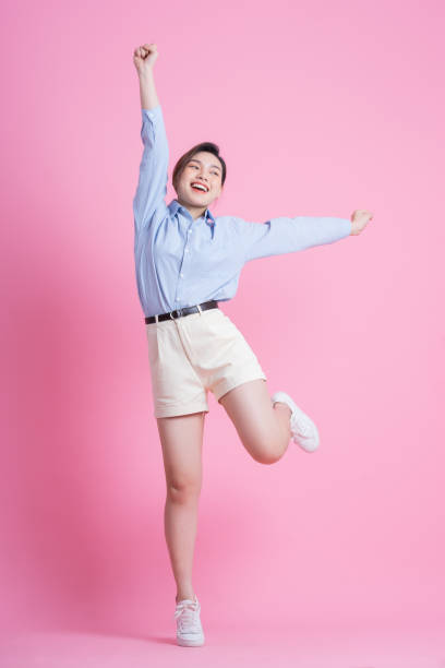 imagem completa de jovem asiática posando em fundo rosa - beautiful enjoyment surprise elegance - fotografias e filmes do acervo