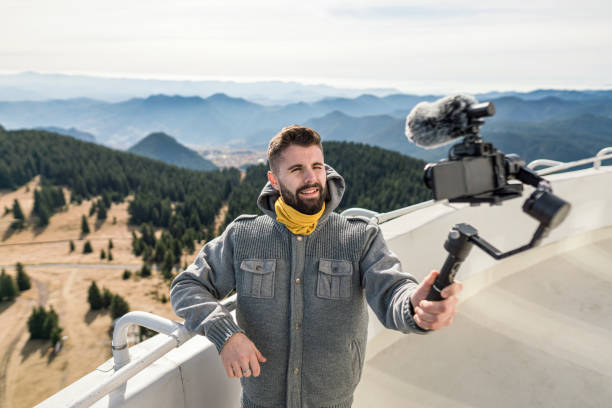 istock Man shooting video in the mountains 1388519143