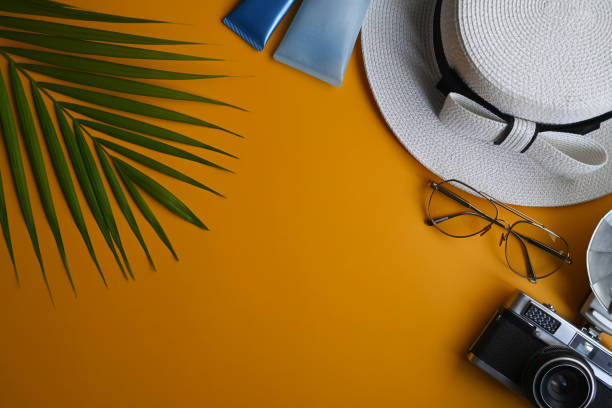 istock Beach summer accessories with glasses, hat, sunscreen bottles and camera on yellow background. Summer vacation concept. 1388520775