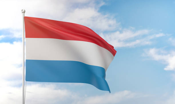Luxembourg flag waving in the blue sky. Politics and Government Concept.