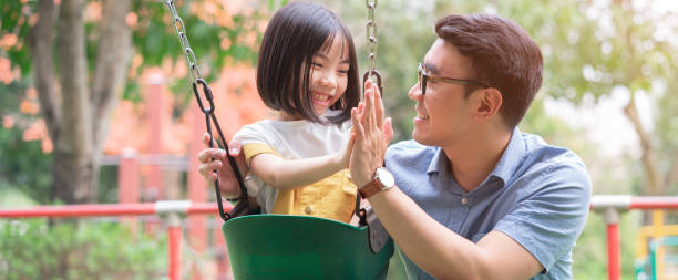 Image of Asian father and daughter playing together at park Image of Asian father and daughter playing together at park happy filipino family stock pictures, royalty-free photos & images