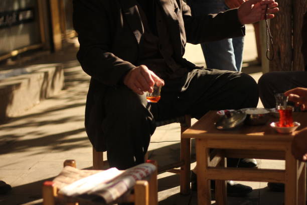 Mandalay, Myanmar - November 10, 2011: A young man at a sidewalk cafe pours hot water and condensed milk into a cup of tea. Tea is an important part of Burmese culture.