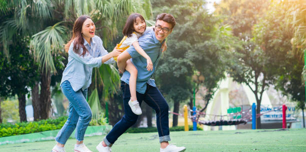 imagen de una joven familia asiática jugando juntos en el parque - baby mother summer park fotografías e imágenes de stock