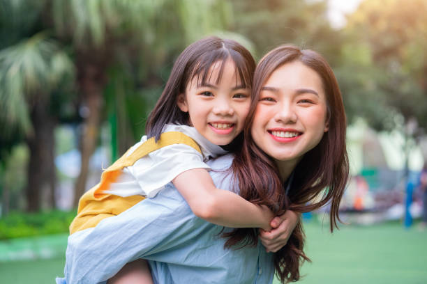 Asian mother and daughter playing together at park Asian mother and daughter playing together at park happy filipino family stock pictures, royalty-free photos & images