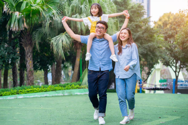 Image of young Asian family playing together at park Image of young Asian family playing together at park filipino family stock pictures, royalty-free photos & images