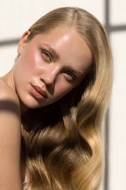 Close up studio shot of a beautiful natural blonde woman. Natural sunlight.