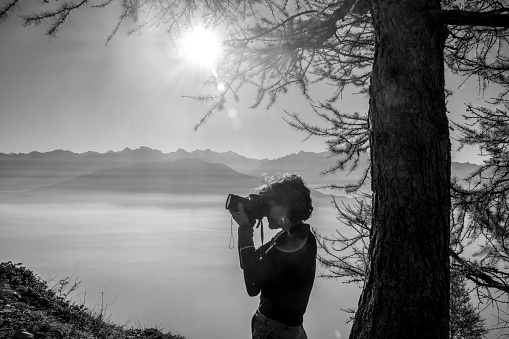 Female hiker takes photos from mountain ridge