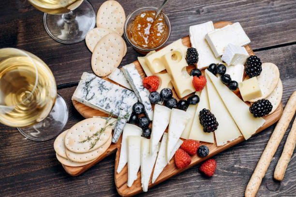 크립세 고르곤졸라 파르메산 브리 또는 카망베르와 마스담. 열매와 크래커와 함께 제공됩니다. 나무 판에 치즈. - cheese wine food parmesan cheese 뉴스 사진 이미지