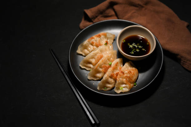 istock Black table background with a plate of an Asian fried dumplings 1388537756