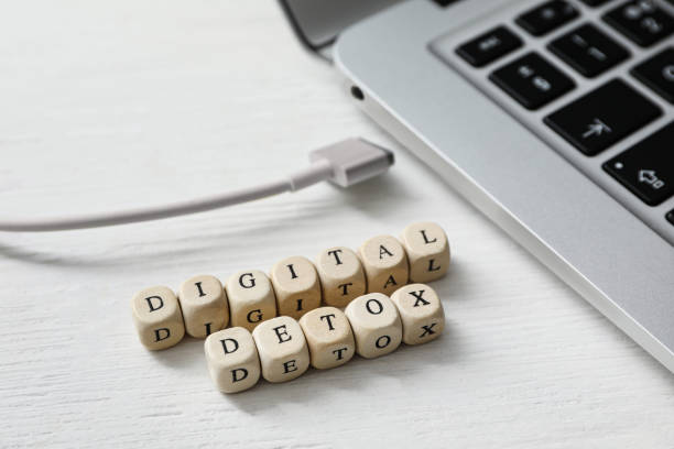 istock Cubes with words DIGITAL DETOX and disconnected charging cable on white wooden background 1388539132