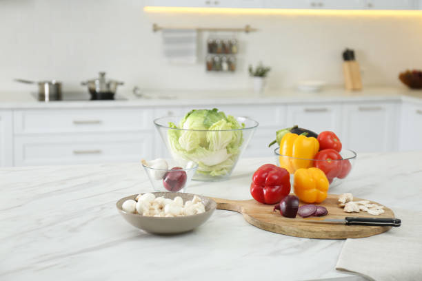 istock Different fresh vegetables and mushrooms on white table in modern kitchen 1388539306