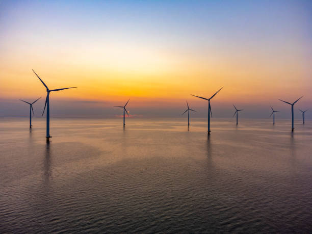 istock Wind turbines in an offshore wind park producing electricity during sunset. 1388540915