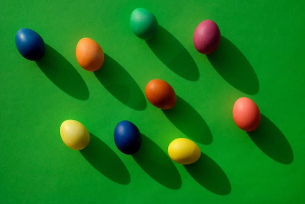 istock Easter eggs on green background, with sunlight and shadows, top view 1388541500